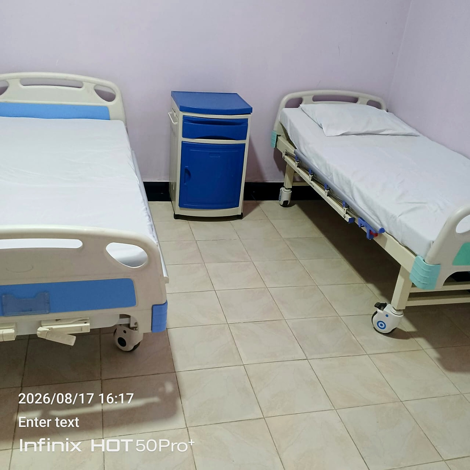 Inpatient ward with clean hospital beds and bedside cabinets
